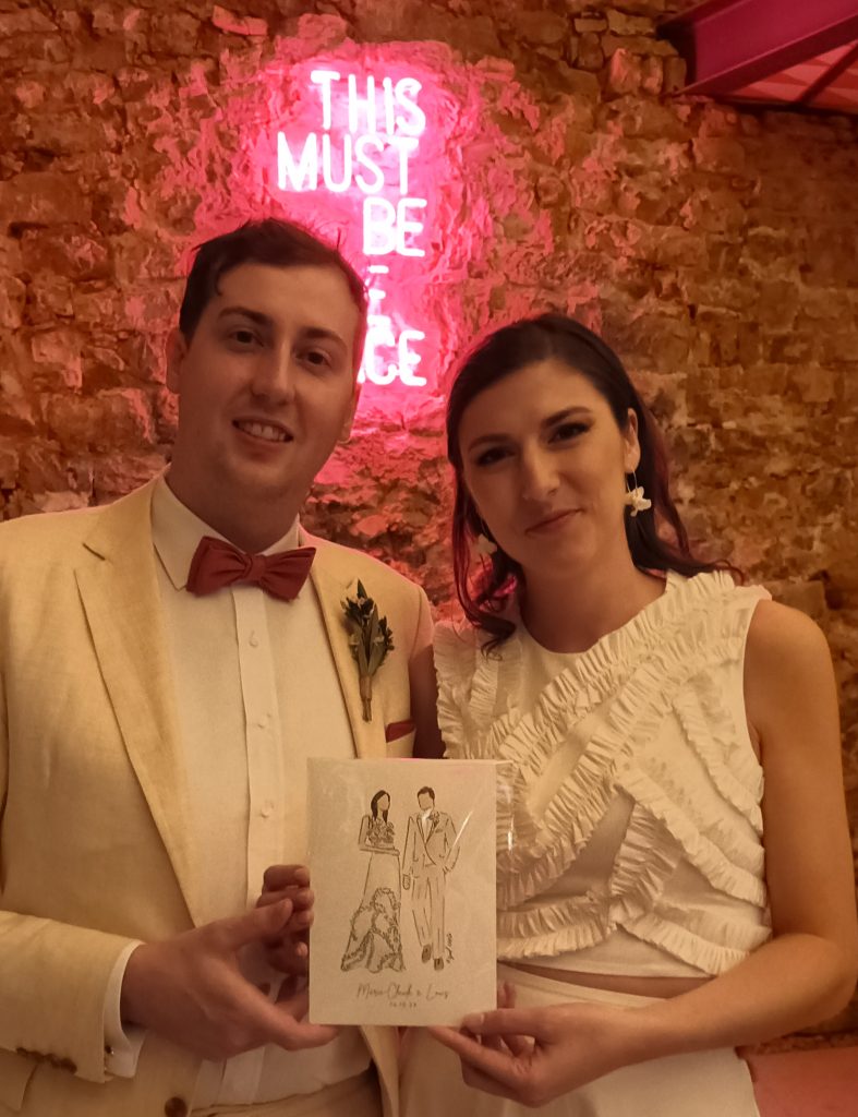 Pareja de novios el día de su boda con el retrato hecho en directo.