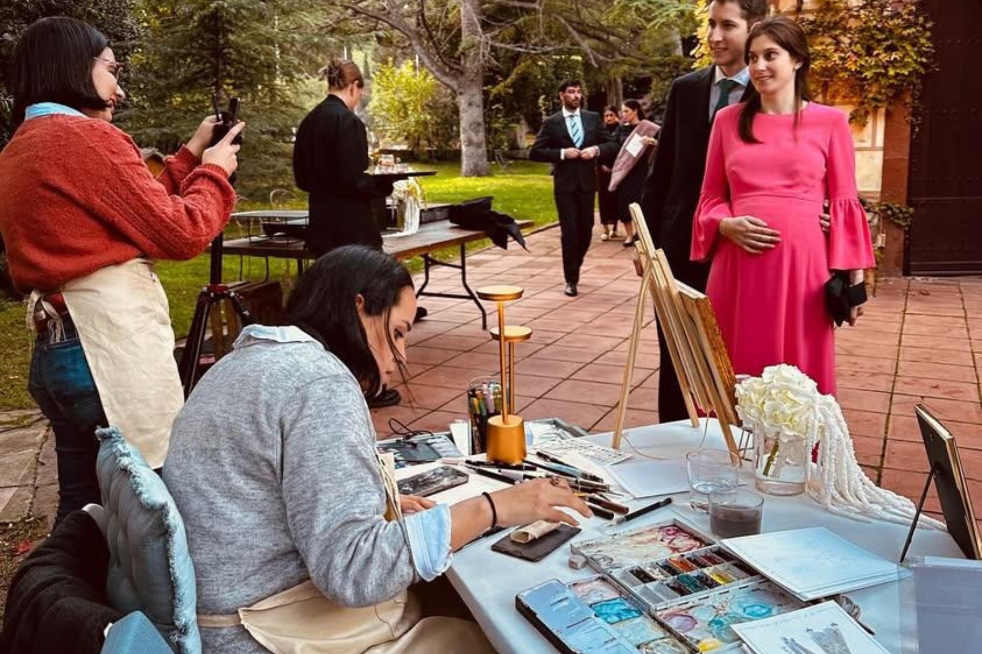 Ilustradora realizando retratos en directo a invitados durante un cóctel de boda al aire libre